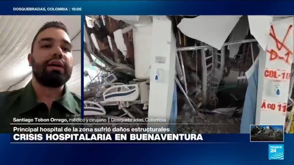A male doctor with a beard appears on a video call from Dosquebradas, Colombia, with images of hospital damage visible behind him showing destroyed medical equipment and structural damage.