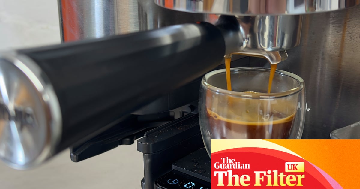 A stream of dark espresso pours from a portafilter into a clear glass cup positioned beneath a Ninja espresso machine's group head.