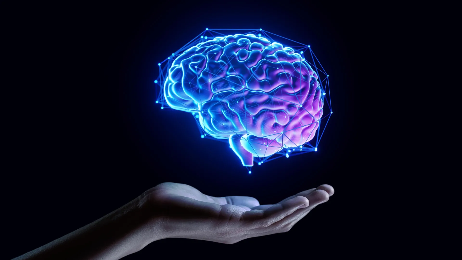 Una mano abierta sostiene un cerebro digital que brilla con luz azul y púrpura neón contra un fondo negro.