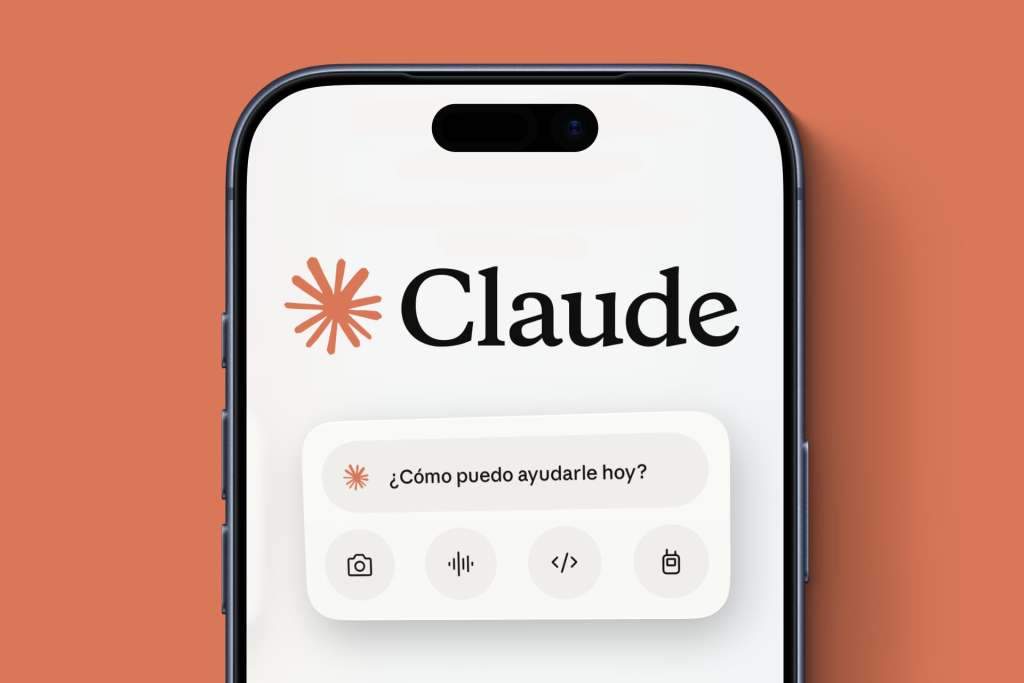 Un teléfono inteligente muestra la interfaz de Claude con un mensaje en español "¿Cómo puedo ayudarle hoy?" y cuatro iconos de herramientas debajo, incluidos opciones para cámara, audio, código y archivos.