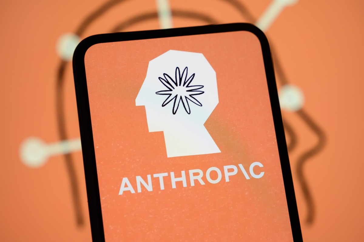 Un teléfono móvil muestra el logo de Anthropic: la silueta blanca de un perfil humano con una explosión de líneas en la cabeza sobre fondo naranja.