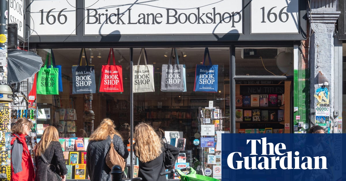 La fachada de Brick Lane Bookshop, una librería independiente ubicada en el número 166, con varios clientes mirando los escaparates y bolsas de compra del establecimiento colgadas en la ventana.
