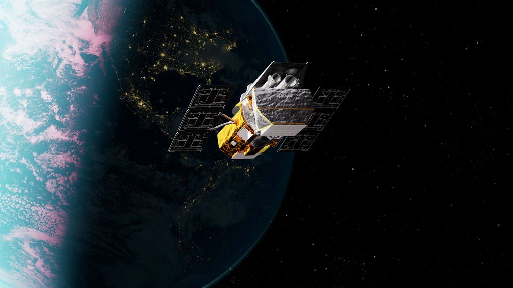 A satellite with gold-colored components and solar panels orbits above Earth, with city lights visible on the night side of the planet below.